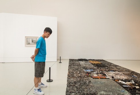 周洲同学正专心致志地观看展览作品