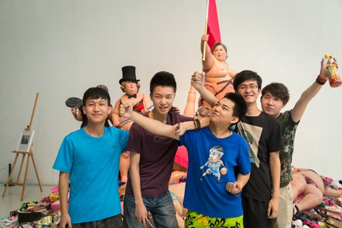 同学们在展览作品前学摆作品中人物的造型并拍照留念